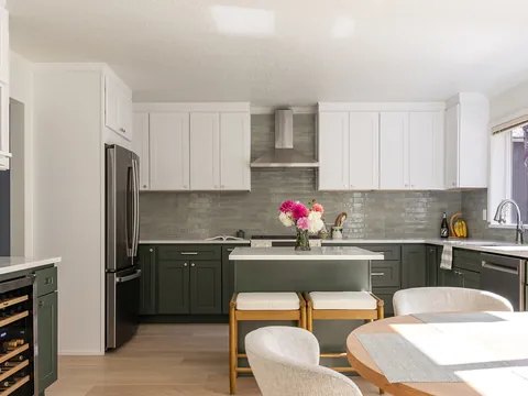 Sage green kitchen with white upper cabinets