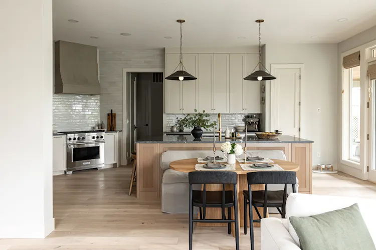 Open kitchen with a wood island, pendant lights and dining table, remodeled by JDI Construction